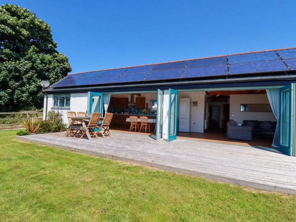 a house with a deck with a solar roof at Little Chywoon Barn in Truro