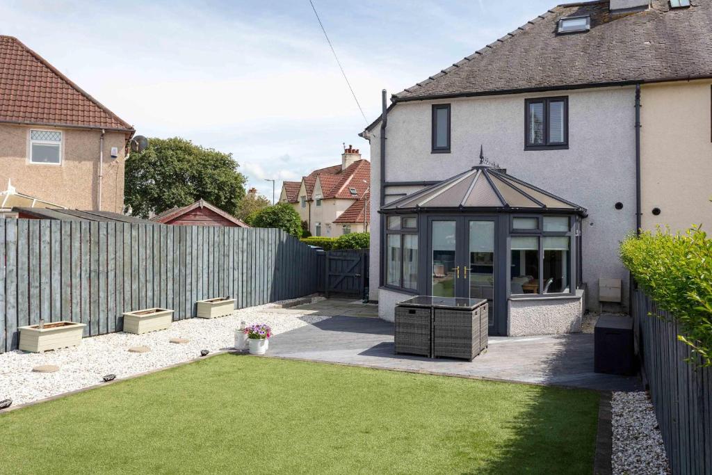 a garden with a house with a gazebo at No15 Ellis House - Donnini Apartments in Kilmarnock
