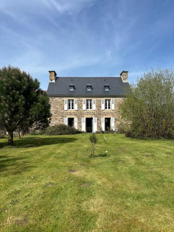 un grande edificio in mattoni in un campo d'erba di Ti Yoco a Ploubazlanec
