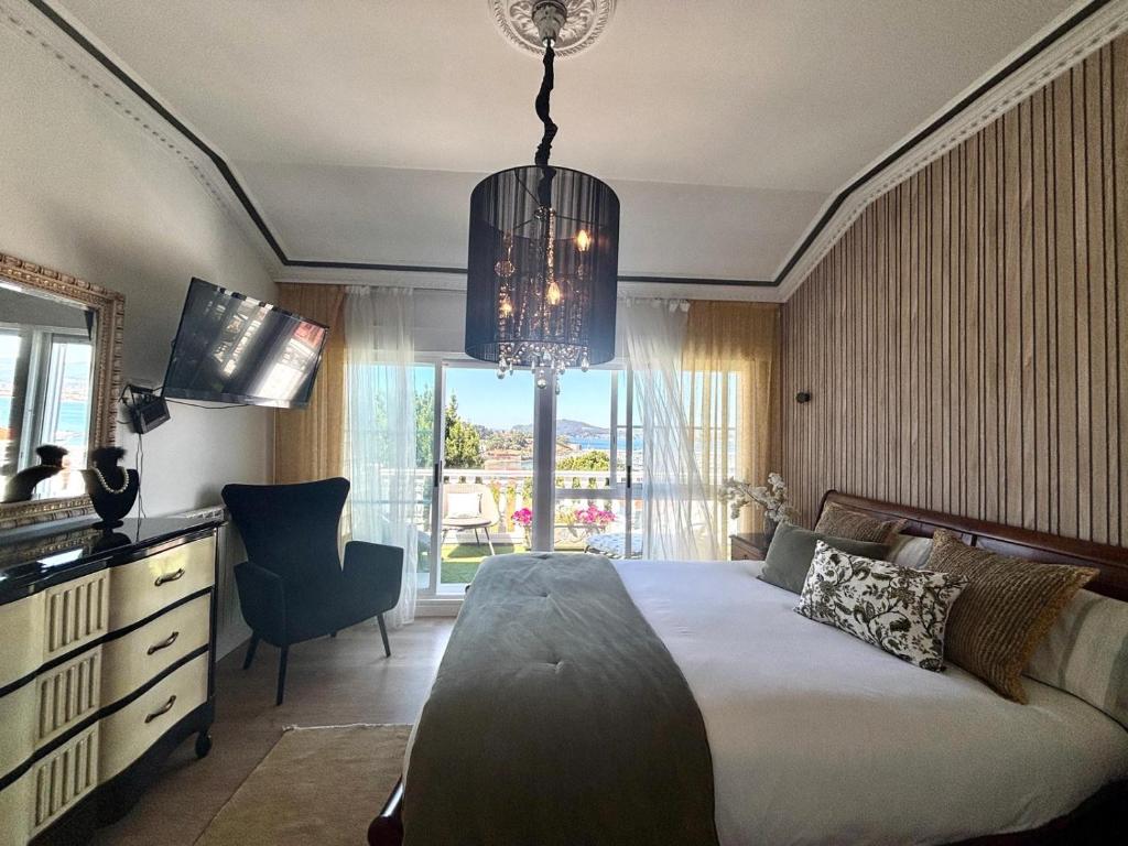 Un dormitorio con una cama y una lámpara de araña en Holibai, Serenidade, Escapada navideña de lujo frente al mar con spa privado y cerca de las mágicas luces de Vigo, en Baiona