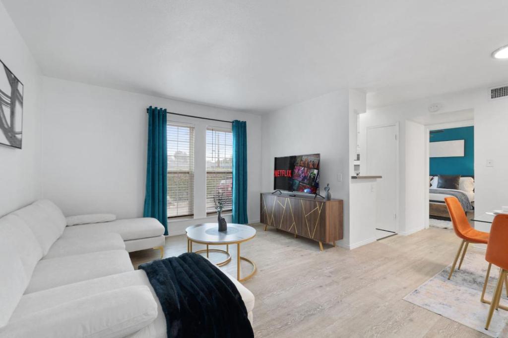 ein Wohnzimmer mit einer weißen Couch und einem Tisch in der Unterkunft Spacious 1 Br Apt Next 2 Dwntown in Austin