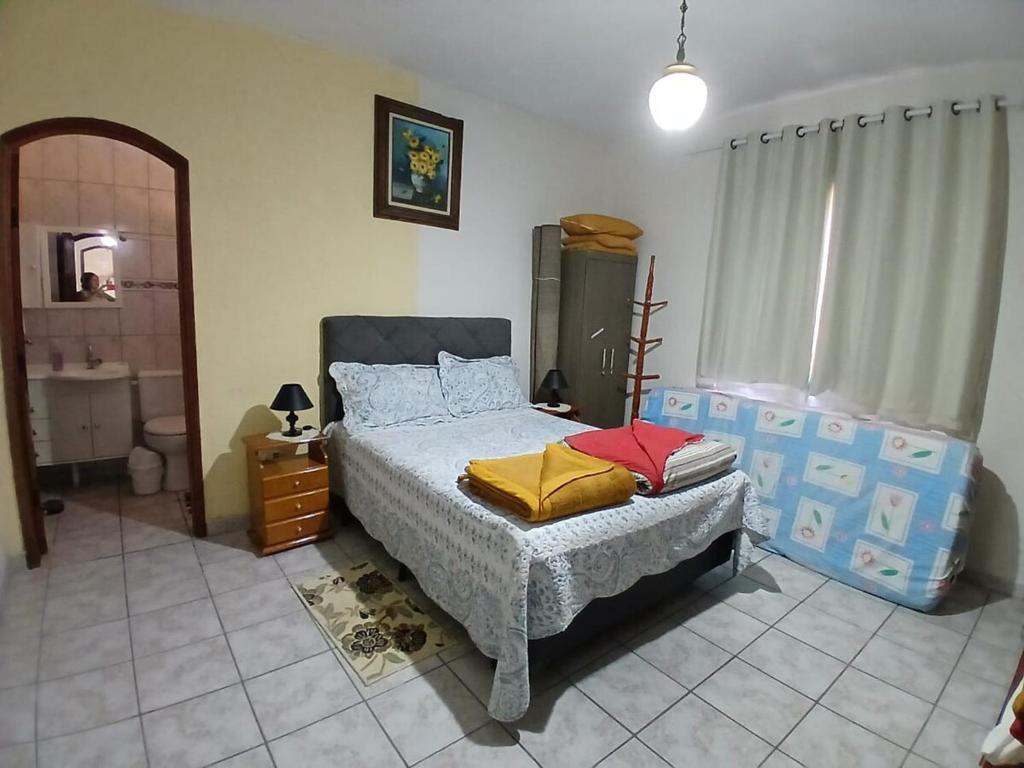 サン・ベント・ド・サプカイーにあるCasa Descanso São Bento Sapucaíの大きなベッドとバスルームのある寝室