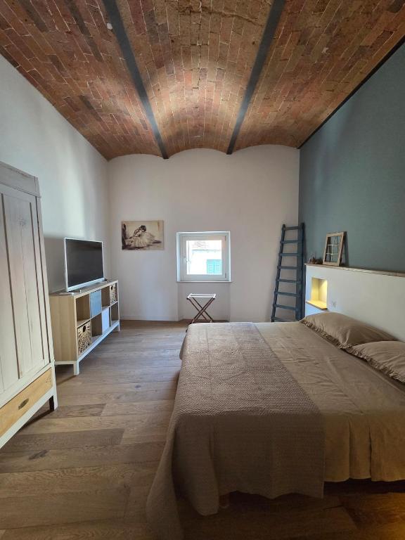 a bedroom with a large bed with a wooden ceiling at A casa di Sonia in Cerreto Guidi