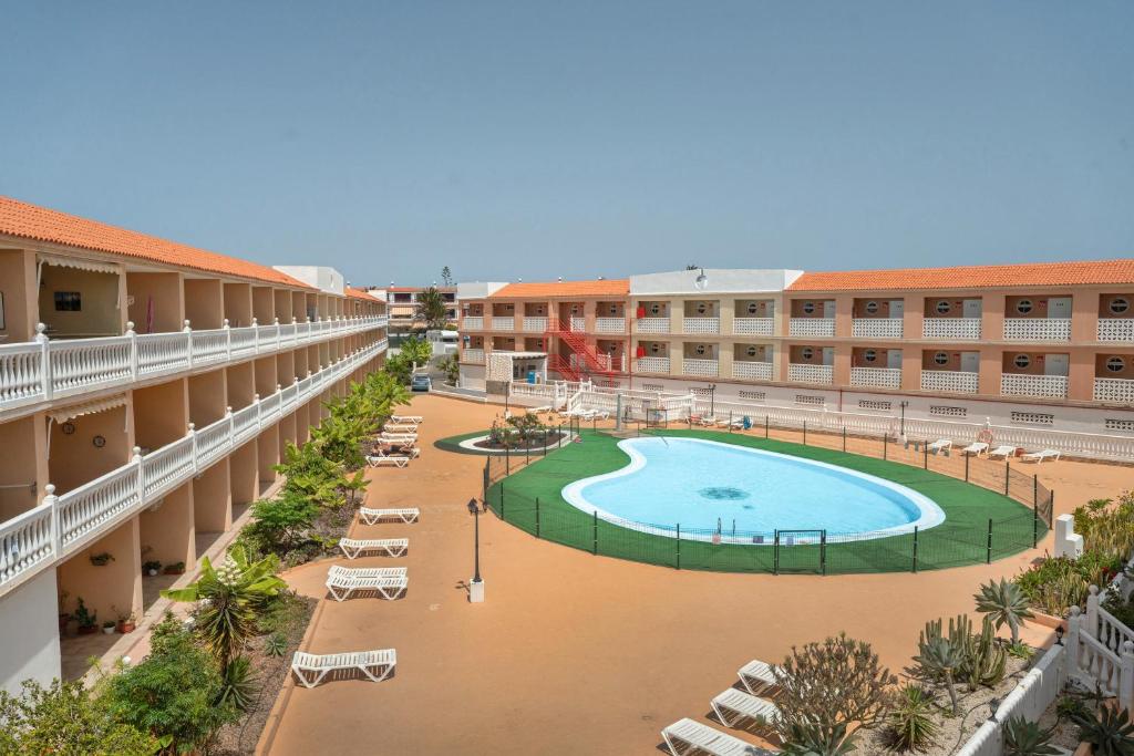 an empty hotel courtyard with a swimming pool and chairs at Parque Carolina 207 in Costa Del Silencio