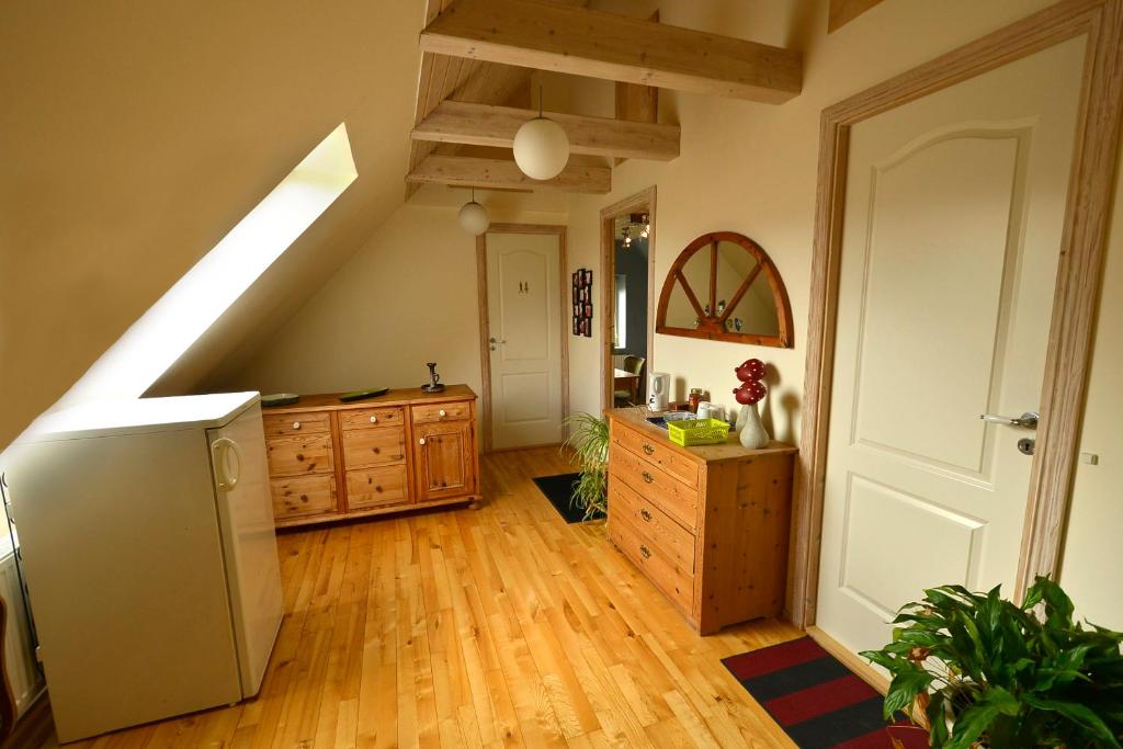 an attic room with a kitchen with a refrigerator and wooden cabinets at Kardybvej 8 in Tastum
