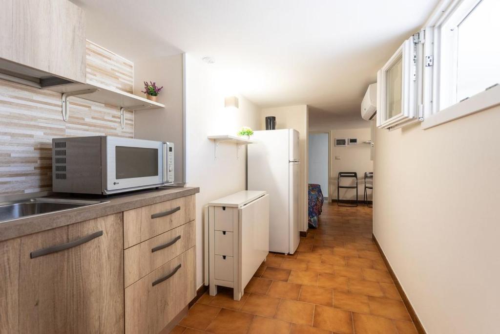 una cocina con nevera y microondas en Dimora Mini Coccola - Salento Reservation, en Ugento