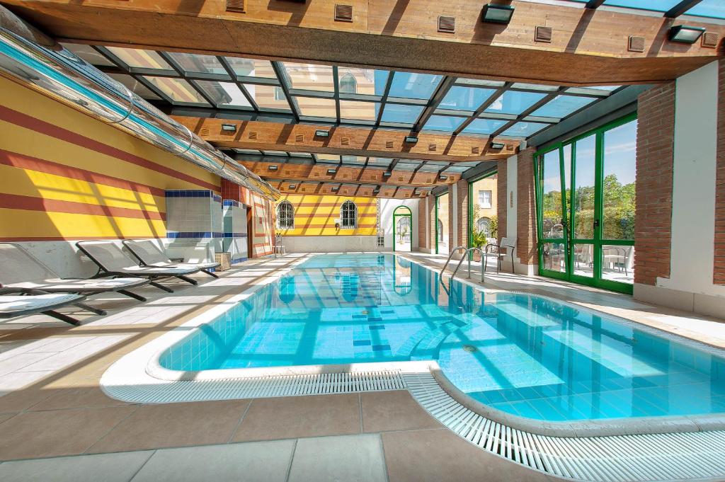 - une grande piscine dans un bâtiment doté de fenêtres dans l'établissement Hotel Villa Malaspina, à Castel d'Azzano