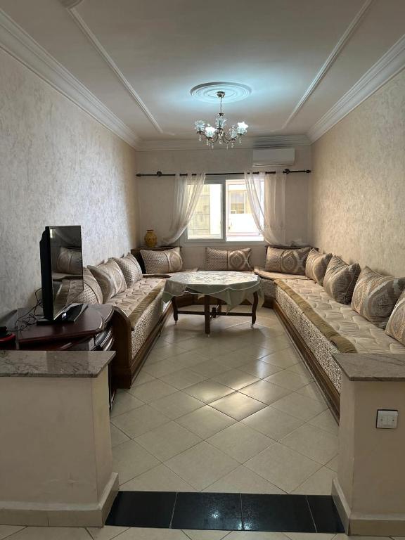 a living room with a couch and a table at Appartement à usage familial in Agadir