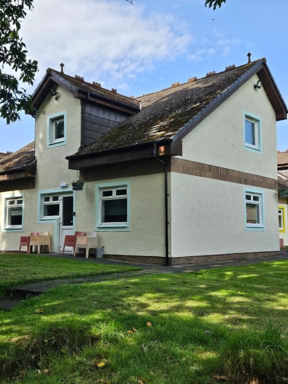 a house with two benches in front of it at Cunninghame 4 in Beith