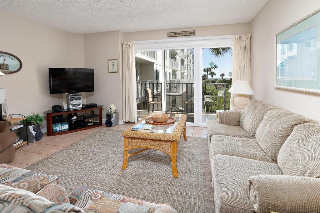 a living room with a couch and a table at Beach Club #118 in Saint Simons Island