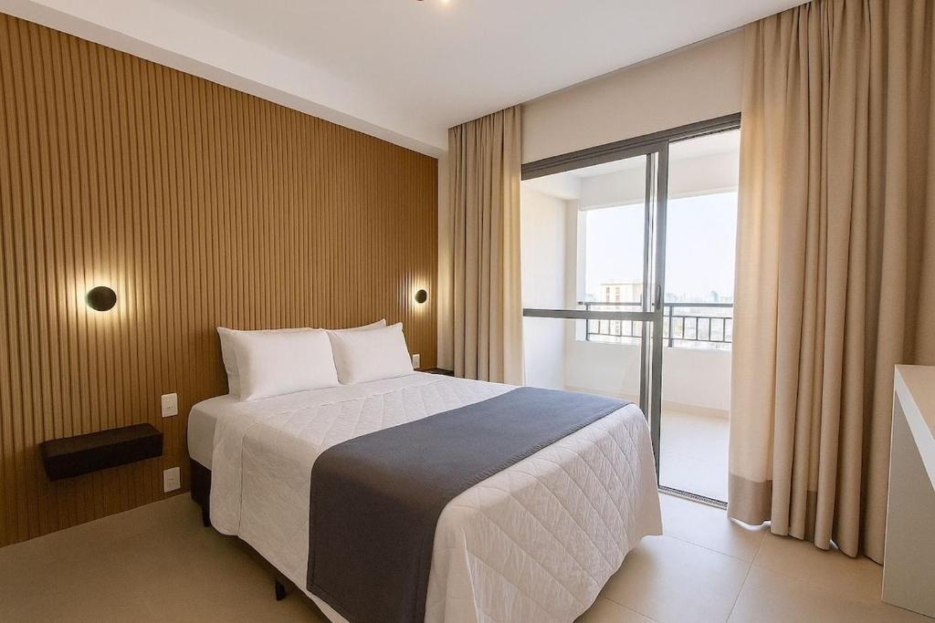a hotel room with a bed and a large window at Otima localizacao metro Sacoma Aeroporto Congonhas Av Paulista Great location 80m subway near Av Paulista and Congonhas Airport Smart TV 50 free channels 600gb WiFi Pool Gym in Sao Paulo