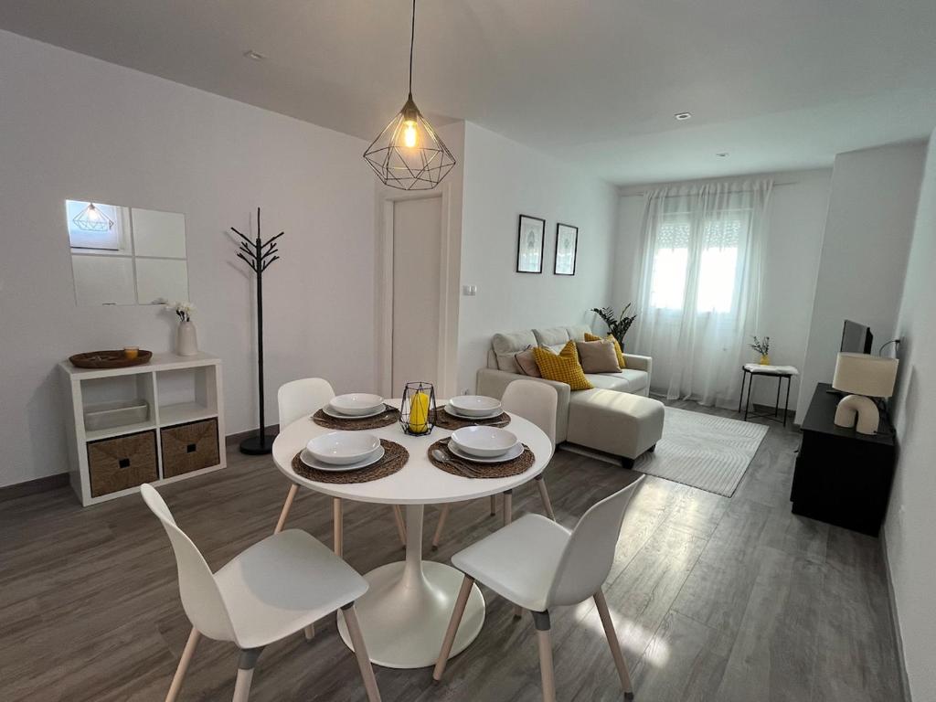 a white living room with a table and chairs at Apartamento Solpor in A Guarda