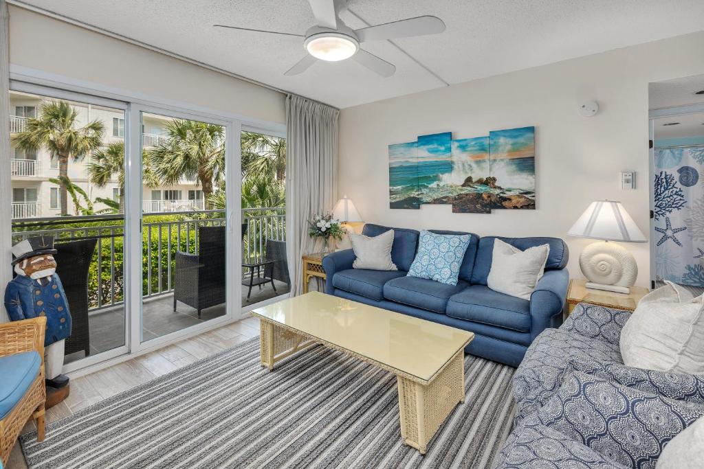 a living room with a couch and a table at Beach Club #127 in Saint Simons Island
