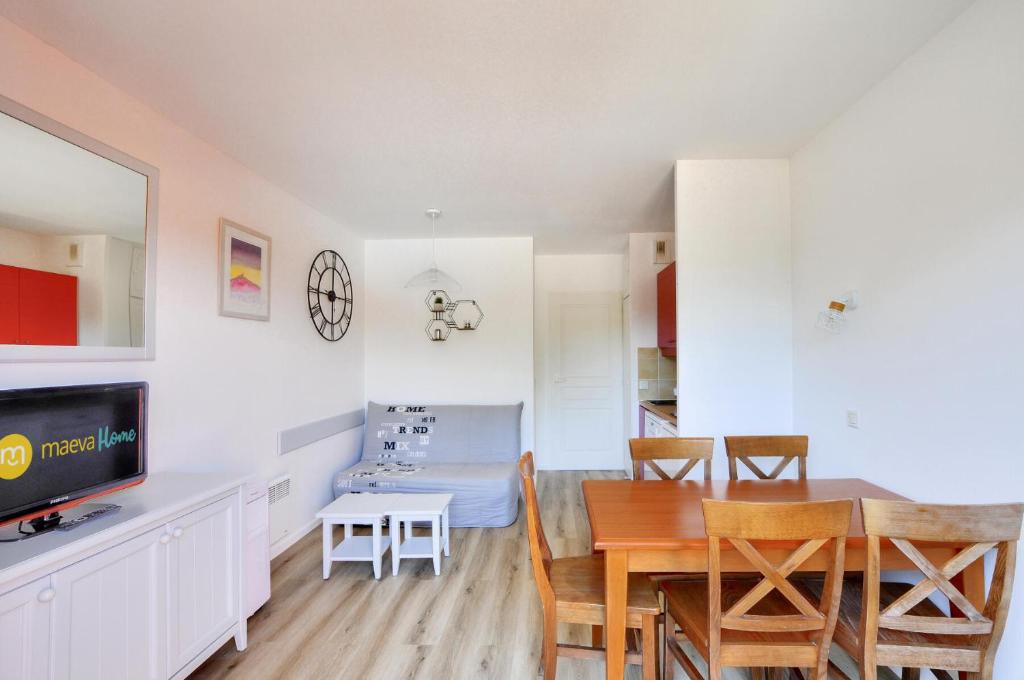 une cuisine et une salle à manger avec une table et des chaises dans l'établissement La résidence du Lac - maeva Home - Appartement 2 pièces 4 personnes - Sélection MAE-7331, à Monflanquin