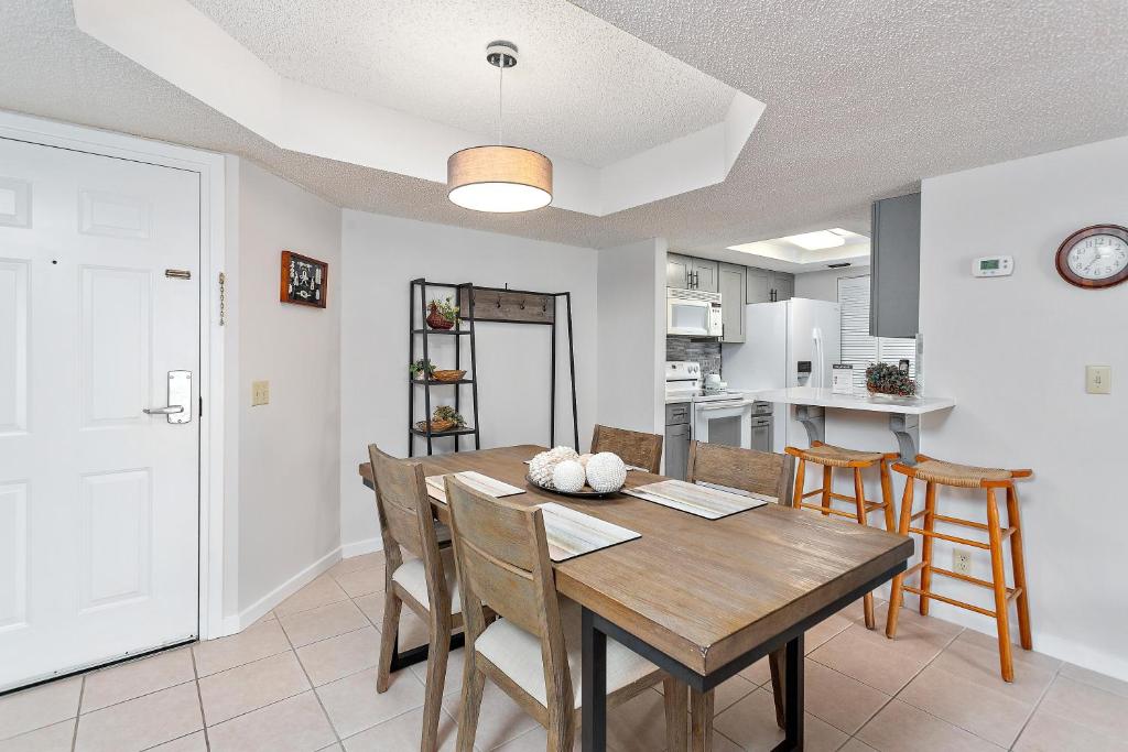 a dining room with a wooden table and chairs at Beach Club #224 in Saint Simons Island