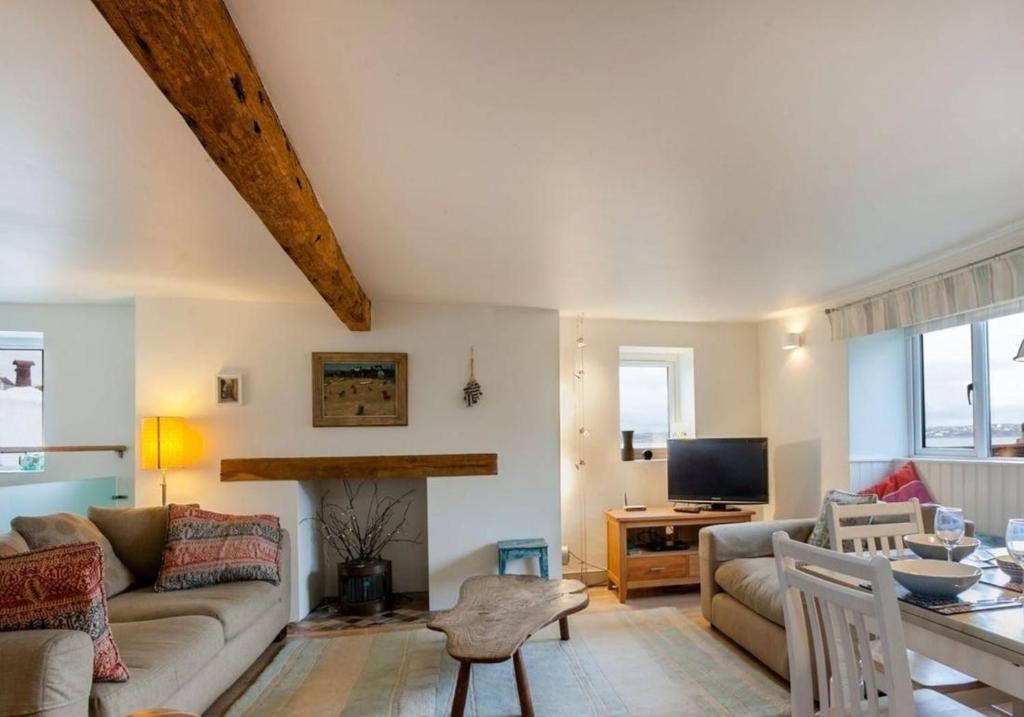 a living room with a couch and a table at Sundeck in Brixham