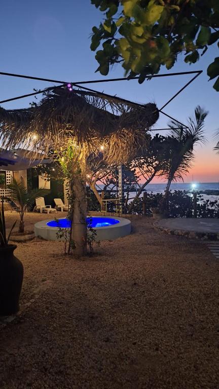 a straw umbrella on the beach at night at Habitación frente al mar y alberca in Lerma