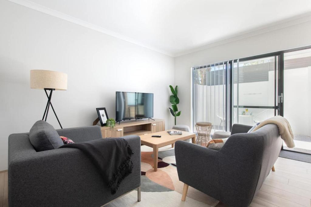 a living room with two couches and a tv at Modern Cozy Spacious 3 Bdrm 2bath,freo,parking,ac in Perth