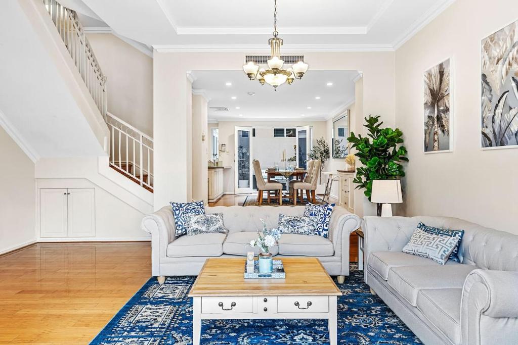 ein Wohnzimmer mit zwei Sofas und einem Tisch in der Unterkunft East Perth Luxury Waterfront Retreat in Perth