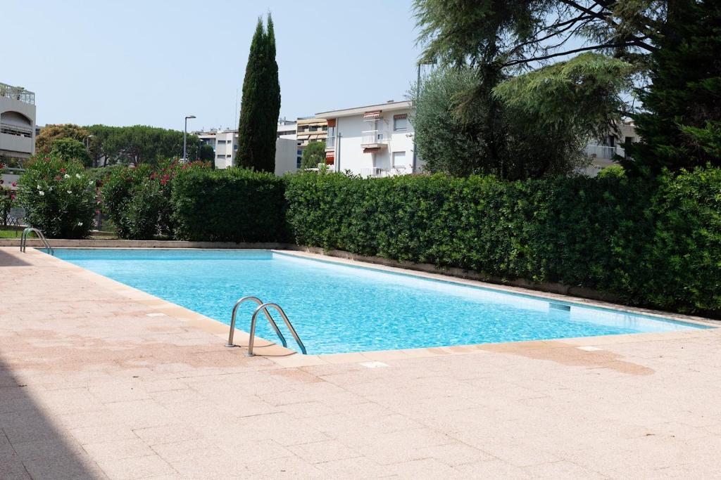 une piscine avec un escalier devant un immeuble dans l'établissement Flat with swimming pool close to the sea, à Cagnes-sur-Mer