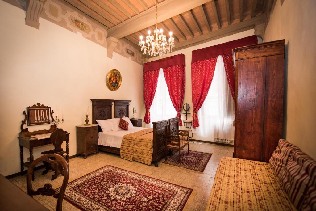 1 dormitorio con cama y lámpara de araña en All'ombra della Torre only Rooms, en Siena