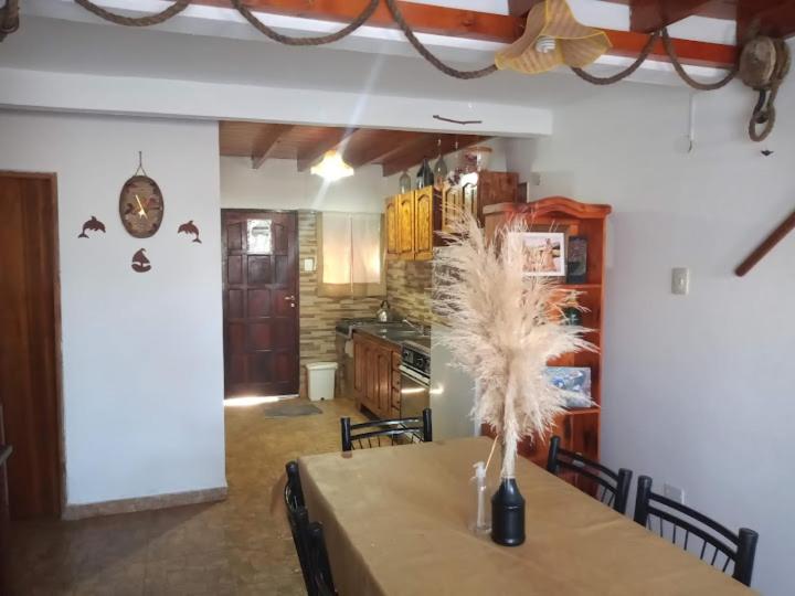 a dining room with a table and a kitchen with bats on the wall at Rancho aparte duplex in San Clemente del Tuyú