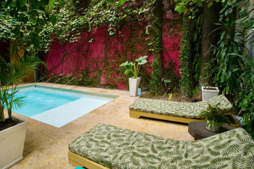 a swimming pool in front of a wall with plants at Hotel Barahona Cartagena in Cartagena de Indias