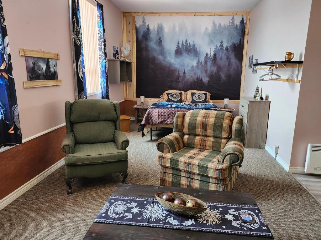 a living room with a bed and a couch and chairs at Norse Skol Accommodations in Griguet