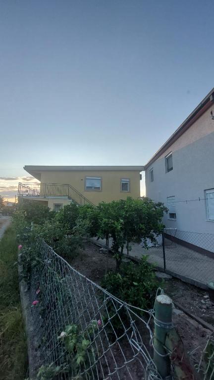 a building with a fence in front of a garden at 2-Bedrooms apartment Koviljka in Bar