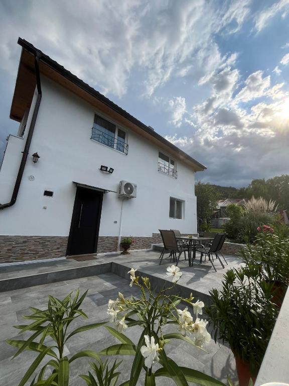 a white house with a patio with tables and chairs at Casa Anna&Criss in Orşova