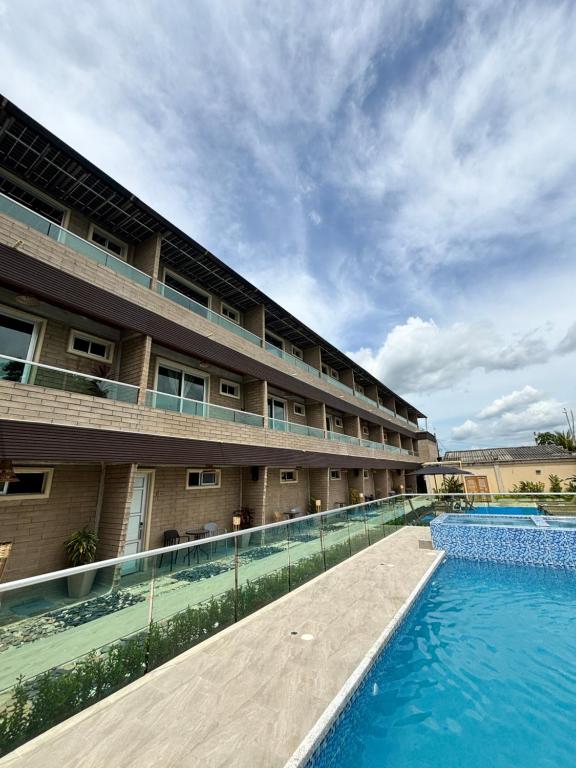 a hotel with a swimming pool in front of a building at Hotel Nazareno Coveñas in San Antero