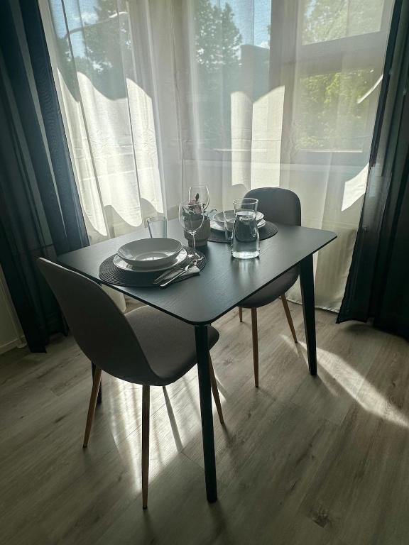 a table with plates and glasses on top of it at Modern studio, good location, free parking in Kuopio
