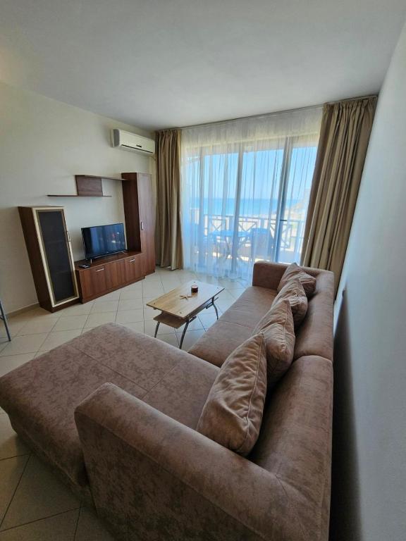 a living room with a large brown couch in a room at Lozenets Oasis Beach Home Four in Lozenets