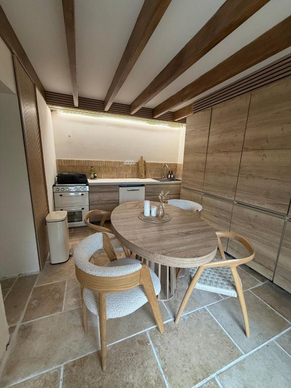 une cuisine avec une table et des chaises en bois dans une pièce dans l'établissement Cocon avec jacuzzi, à Périgny
