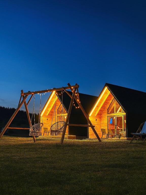 a swing set in front of a log cabin at Eternum Glamping in Žabljak