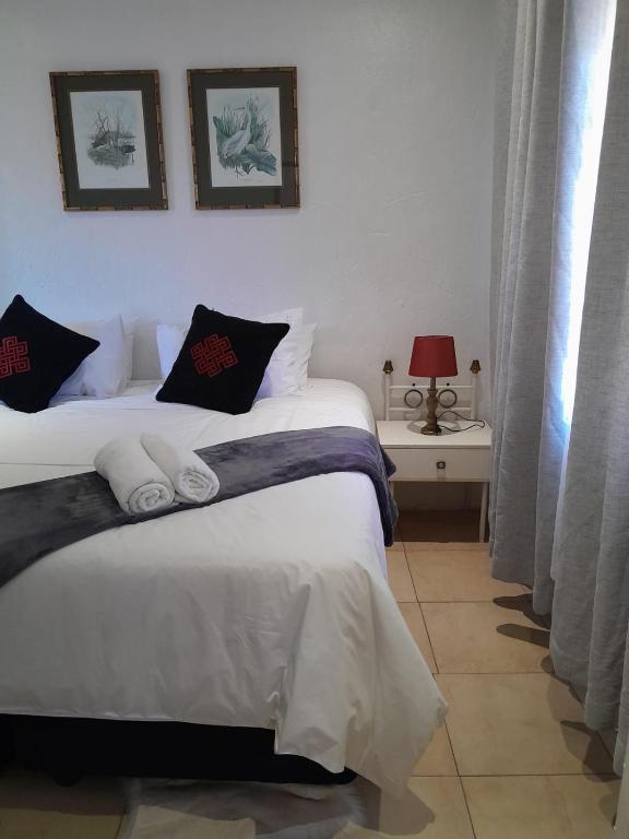 a bedroom with a bed with two pillows at Russell's Rest Apartments in Johannesburg