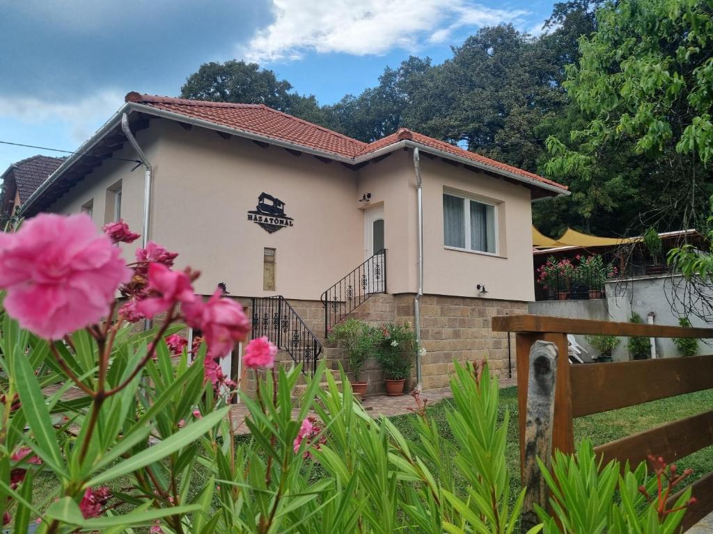 a house with pink flowers in front of it at Ház a tónál Noszvaj in Noszvaj