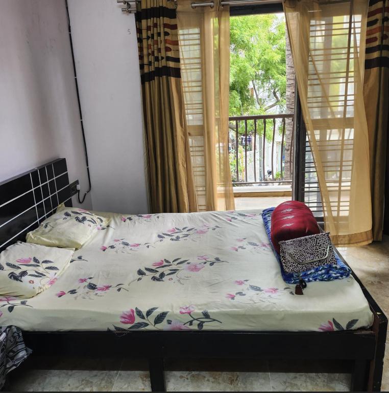 a bed in a room with a window and a bed with a pillow at Bangalore Chalet in Bangalore