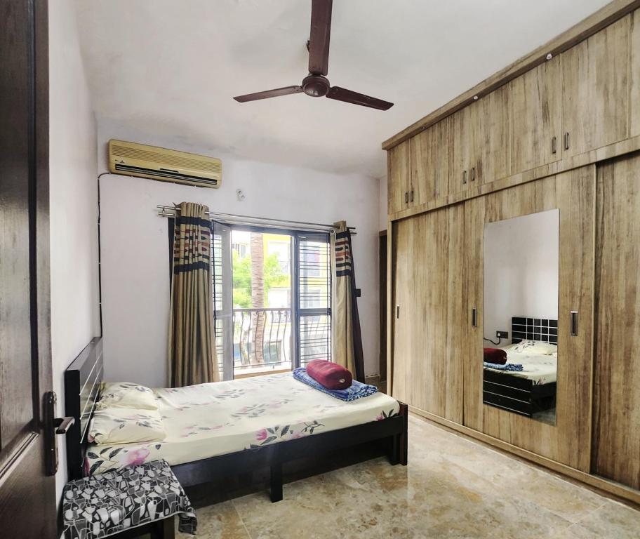 a bedroom with a bed and a mirror and a window at Bangalore Chalet in Bengaluru