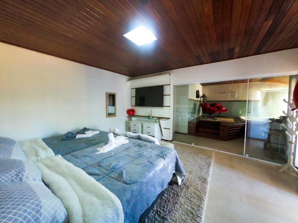 a bedroom with a large bed and a television at Pousada Liberal Liberte-se in Búzios- Somente Adultos in Búzios