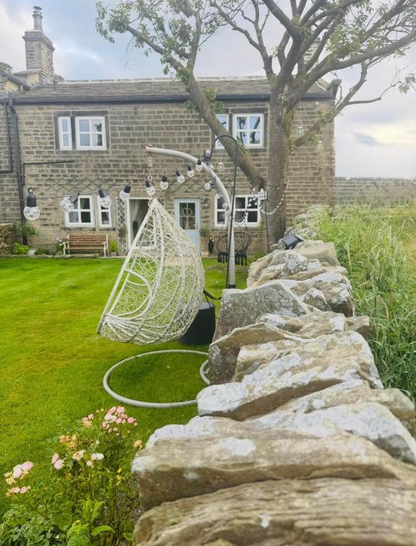a stone retaining wall in front of a house at Bents Holiday Cottage, Views & Parking for two cars in Oxenhope