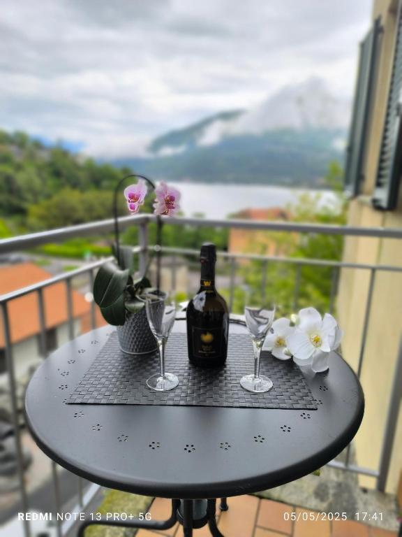 a table with a bottle of wine and glasses on a balcony at Dimora Nella Roccia in San Siro