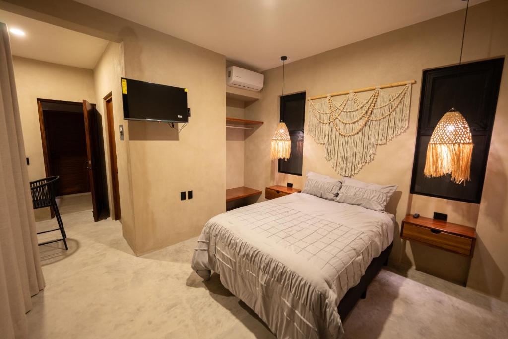 a bedroom with a bed and a flat screen tv at Casa TzinTzun in Temalhuacán