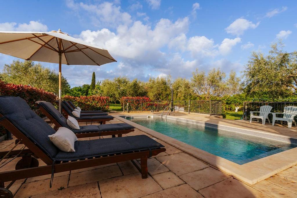 a swimming pool with lounge chairs and an umbrella at Ferienhaus Rovinj mit Pool in Rovinj