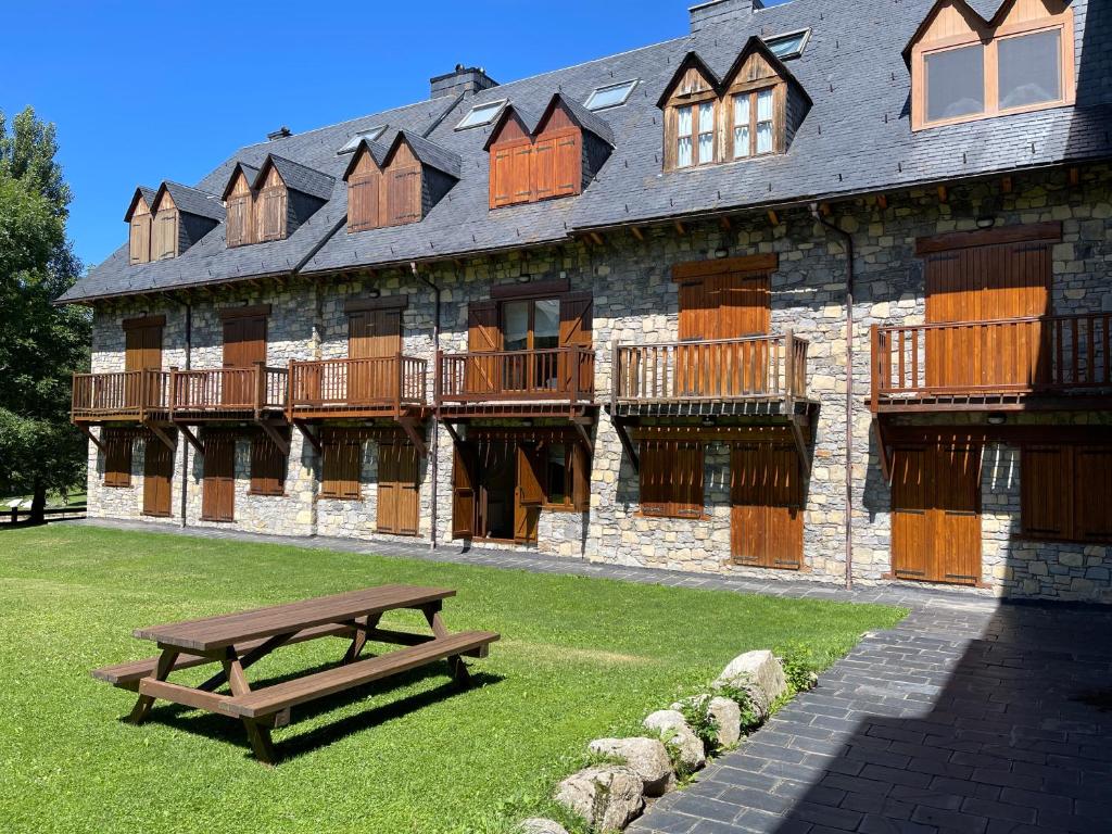a wooden bench in front of a building at La Casa Del Pla in Pla de l'Ermita