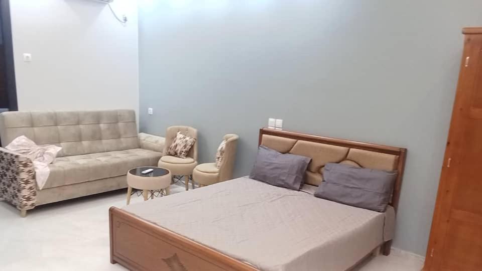 a bedroom with a bed and a couch at Dar El Oualidine belle villa familiale avec piscine privée sans vis a vis 