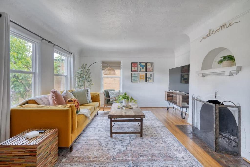 un soggiorno con divano giallo e camino di Cozy Boho 1BR - Walk to Shops & Cafes a Portland
