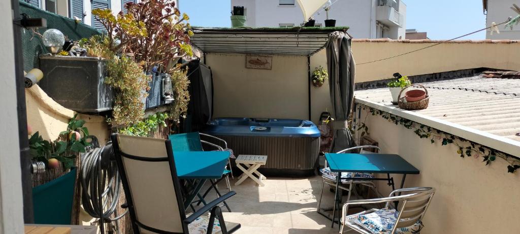 un petit balcon avec des tables et des chaises bleues sur un immeuble dans l'établissement Appartement style Loft avec Jacuzzi à 150m de la plage, à Toulon
