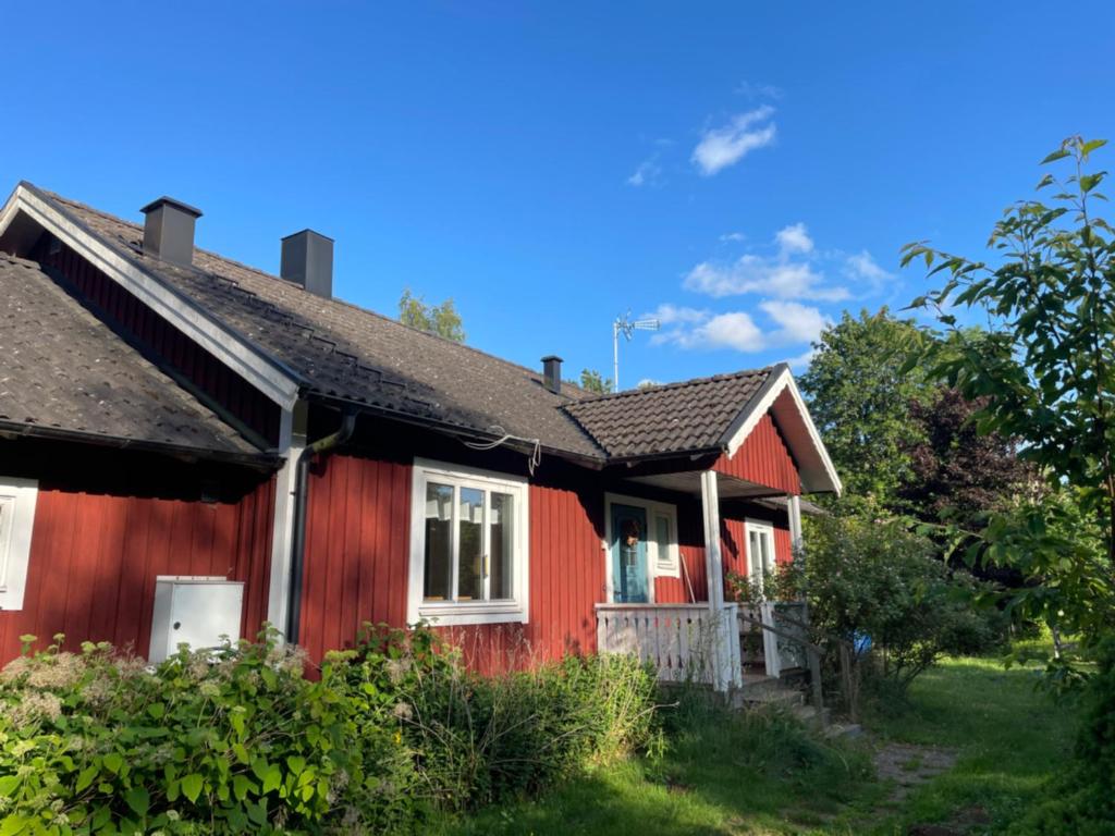 a red house with a black roof at Villa Next to the Forest in Tingsryd