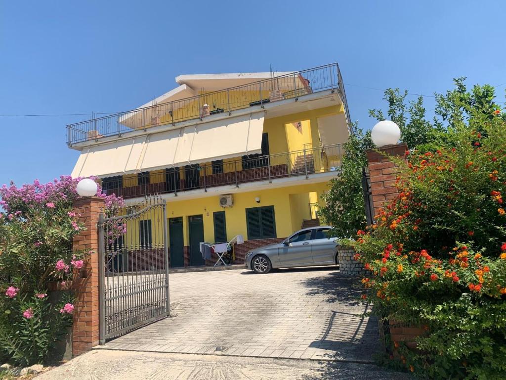 a car parked in front of a yellow house at Kapo Residence in Vlorë